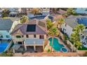 An aerial view of a backyard oasis with a pool, spa, covered patio, and lush tropical landscaping at 395 Suzanne Peak Ct, Henderson, NV 89012