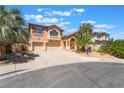 Beautiful desert home with a three-car garage, mature palm trees and a well-manicured lawn at 395 Suzanne Peak Ct, Henderson, NV 89012
