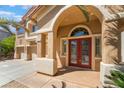 Inviting front entrance featuring a double door, arched entryway and desert landscaping at 395 Suzanne Peak Ct, Henderson, NV 89012