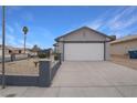 House exterior featuring a two-car garage and desert landscaping at 4401 Mossy Rock Ct, Las Vegas, NV 89108