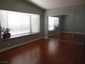 Sunlit bedroom features hardwood floors, a bay window, and mirrored closet doors at 6786 Grandola Dr, Las Vegas, NV 89103