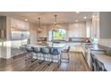 Spacious, bright kitchen featuring white cabinets, stainless steel appliances, and a large center island with seating at 10047 Alden Creek St, Las Vegas, NV 89141
