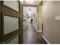 Elegant hallway featuring wood-look tile flooring and modern lighting fixtures, creating a welcoming entrance to the home at 3372 Dalmore St, Henderson, NV 89044