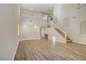 Light-filled living room with high ceilings, wood floors, arched doorways, and staircase to second floor at 8005 Egypt Meadows Ave, Las Vegas, NV 89178