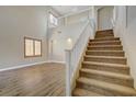 Bright living room features wood floors, vaulted ceiling, staircase and large window with shutters at 8005 Egypt Meadows Ave, Las Vegas, NV 89178