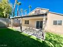 Covered patio, grassy area, and a partially visible fence at 10199 Spider Rock Ave, Las Vegas, NV 89135