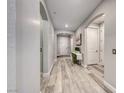 Light and airy hallway featuring wood-look floors, arched doorways, and neutral paint at 29 Sun Mirage Ave, Henderson, NV 89011