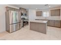 A kitchen featuring stainless steel appliances, an island, and tile flooring at 3634 Tripoli Cove Ave, Las Vegas, NV 89106
