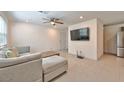 Open living area with sectional sofa, coffee table, and large TV at 3634 Tripoli Cove Ave, Las Vegas, NV 89106