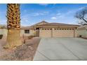 Single story house with a three car garage and mature palm tree at 5130 Stone Cove St, North Las Vegas, NV 89081