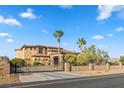 Stately home with stone accents and a gated entrance, set against a backdrop of blue skies at 670 Du Fort Ave, Henderson, NV 89002