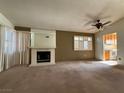 Spacious living room featuring a fireplace and a view into the kitchen at 7588 Kalmalii Ave, Las Vegas, NV 89147