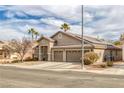 Beautiful home with a desert landscape, palm trees and a three-car garage at 830 Roaring Falls Ave, Henderson, NV 89052