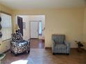 A bright, open living room featuring neutral-colored walls with tile flooring and comfortable furnishings at 9022 Sosa Creek Ave, Las Vegas, NV 89149