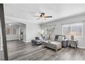 Open-concept living room with grey wood floors, sectional sofa, and lots of natural light at , Las Vegas, NV 89117