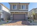 Two-story house with brown garage door and brick paver driveway at 10328 Apefly St, Las Vegas, NV 89141