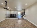 Spacious living room featuring wood-look floors, decorative lighting, and a view of the staircase and dining area at 10618 Timber Stand St, Las Vegas, NV 89183