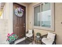 Inviting front porch with chairs, floral wreath on front door and potted plants at 1209 Crystal Grotto Ave, North Las Vegas, NV 89081