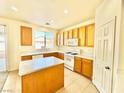 Eat-in kitchen includes a central island, bright window, and ample cabinet storage at 1838 Fighting Falcon Ln, North Las Vegas, NV 89031