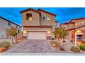 Two-story house with a brick driveway and attached garage, next to similar homes at 200 Denette Ln, North Las Vegas, NV 89031