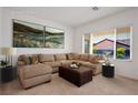 Virtually staged living room with L-shaped sectional sofa and large windows at 2127 Sawtooth Mountain Dr, Henderson, NV 89044