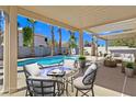 Charming covered patio with ample seating overlooking the sparkling pool, perfect for outdoor dining and relaxation at 283 Fancrest St, Henderson, NV 89052