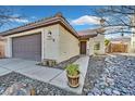 House exterior with a brown garage door and stone landscaping at 3757 Grand Viewpoint Ct, Las Vegas, NV 89147