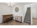 Light and airy foyer with stairs, tiled floors, modern light fixture and bar at 3770 S Rosy Carina Pl, Henderson, NV 89052