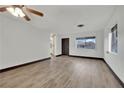 Bright living room featuring wood-look floors, a ceiling fan, and a large window at 4151 Calimesa St, Las Vegas, NV 89115