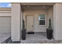 Inviting covered front porch of a home featuring manicured greenery in planters at 4267 E Highvale Ct, Pahrump, NV 89061