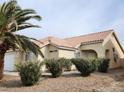 Well-maintained property with mature landscaping, including desert shrubbery and a tile roof at 4610 Cannon Beach St, Las Vegas, NV 89122