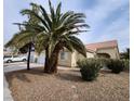 A serene front exterior with rock landscaping, mature trees, and a quaint walkway to the entrance at 4610 Cannon Beach St, Las Vegas, NV 89122