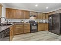 Modern kitchen with wood cabinets and black appliances at 4793 Cannon Hill Ct, Las Vegas, NV 89130