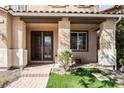 Inviting entryway with beautiful double doors, stone accents, and a glimpse of lush greenery at 1163 Highbury Grove St, Henderson, NV 89002