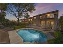 Backyard view showcasing a pristine pool, lush landscaping, and a spacious patio for outdoor entertaining at 1163 Highbury Grove St, Henderson, NV 89002