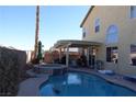 Backyard oasis with a large pool, hot tub, covered patio, and views of mountains at 180 Plumpjack Ave, Henderson, NV 89002