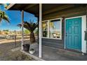 Inviting front porch with teal door and potted plants, offering a relaxing entryway at 207 W Victory Rd, Henderson, NV 89015