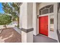 Welcoming front entrance with a vibrant red door, stylish exterior lighting, and attractive landscaping at 2133 Linden Tree St, Las Vegas, NV 89156