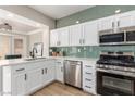 Modern kitchen with white cabinets, stainless steel appliances, and an attractive green subway tile backsplash at 2401 Rockford St, Las Vegas, NV 89134