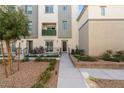 Exterior view of a modern multi-story home with a small yard, a balcony and landscaping at 2844 Copper Wind Ln # 4, Las Vegas, NV 89183