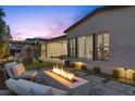 Backyard patio with modern fire pit, lounge chairs, and outdoor seating area at 3025 Merlesco Ave, Henderson, NV 89044