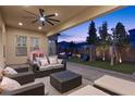 Covered patio with ceiling fan, comfortable seating, and a view of the backyard play area at 3025 Merlesco Ave, Henderson, NV 89044