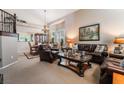 Elegant living room featuring plush leather seating, a chandelier, and a view into the dining room at 306 Treehouse Ct, Henderson, NV 89012