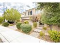 Beautiful two-story home featuring landscaped front yard, complemented by lush trees providing shade and privacy at 3163 Biccari Ave, Henderson, NV 89044