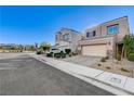 Attractive two-story home featuring a paved driveway, a two-car garage, and desert landscaping with a clear blue sky at 387 Layla Bay St, Henderson, NV 89014