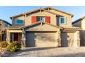 Charming two-story home featuring a three-car garage, brick driveway, and lovely red shutters at 4220 Porticella Ave, North Las Vegas, NV 89084