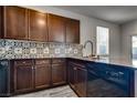 A kitchen featuring dark cabinets, granite countertops, designer backsplash, and stainless steel appliances at 4626 Lime Straight Dr, Las Vegas, NV 89115