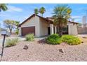 Front of home features desert landscaping, palm trees, and a covered porch at 4716 Mountain Valley Rd, Las Vegas, NV 89121