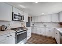 Bright kitchen featuring white cabinets, stainless steel appliances, and wood floors at 4815 Palacio Ct, Las Vegas, NV 89122