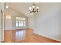 Bright living room features vaulted ceilings, wood floors, and updated chandelier at 6086 Shadow Oak Dr, North Las Vegas, NV 89031